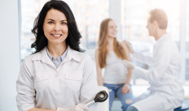 Doutora sorrindo com pacientes ao fundo