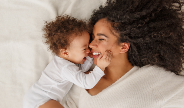 Mãe sorrindo com filha bebê