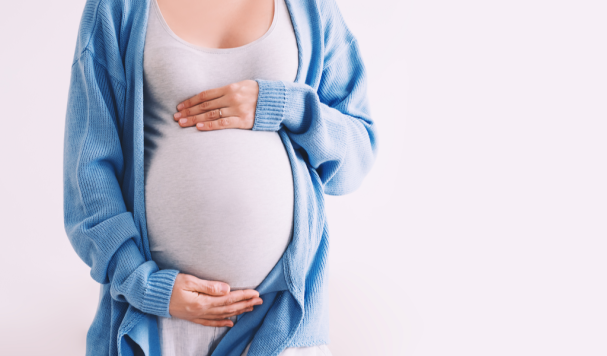 Mulher grávida com mãos na barriga